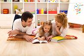 picture of family  - Happy family laying on the floor reading in the kids room - JPG 