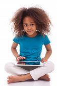 picture of asian  - Little african asian girl using a tablet pc isolated on white background - JPG 