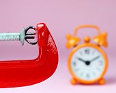 picture of pressure  - A silver Euro symbol placed in a red clamp with a pastel pink background - JPG 