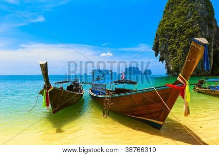Picture or Photo of Travel landscape, beach with blue water and sky at summer. Thailand nature beautiful island and traditional wooden boat. Scenery tropical paradise resort.
