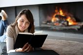 picture of rest  - Portrait of beautiful woman reading book by fireplace - JPG 