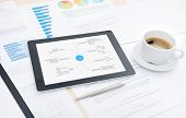 stock photo of finance  - Modern digital tablet with business plan on screen cup of coffee and some papers and documents with charts and numbers on a desktop in office - JPG 