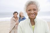 stock photo of beach  - Portrait of happy African American senior woman with friends at beach - JPG 