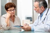 stock photo of medical doctors  - doctor talking to his female patient at office - JPG 