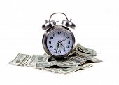 image of money  - an isolated alarm clock places atop lots of money for the concept of time and money - JPG 