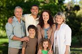 picture of family  - Smiling Family Looking At The Camera In The Park - JPG 