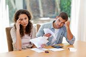 image of money  - Young couple calculating their domestic bills at home - JPG 