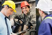 picture of industrial  - Portrait of happy young forklift driver with supervisor holding clipboard at warehouse - JPG 