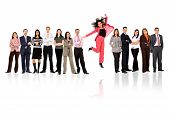 picture of business people  - business woman jumping with her business team formed of young businessmen and businesswomen standing over a white background with reflections - JPG 