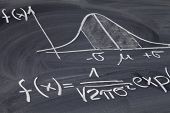 foto of normal  - Gaussian bell or normal distribution curve with equation sketched with white chalk on a blackboard - JPG 