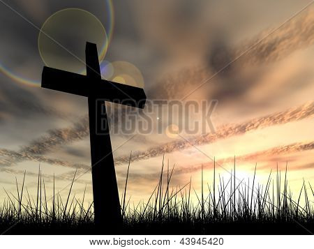 Picture or Photo of Concept conceptual black cross or religion symbol silhouette in grass over a sunset or sunrise sky with sunlight clouds background