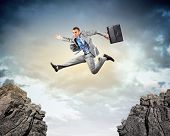 image of gap  - Image of young businessman jumping over gap - JPG 