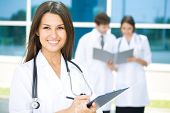 stock photo of medical doctors  - Portrait of a female doctor with two of her co - JPG 