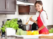 foto of food  - Cooking woman in kitchen stirring in pot making food for dinner - JPG 