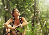 stock photo of break  - Young beautiful woman with walking sticks in a forest having a break - JPG 