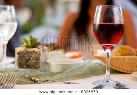 Picture or Photo of The served table with red wine at restaurant (shallow dof)